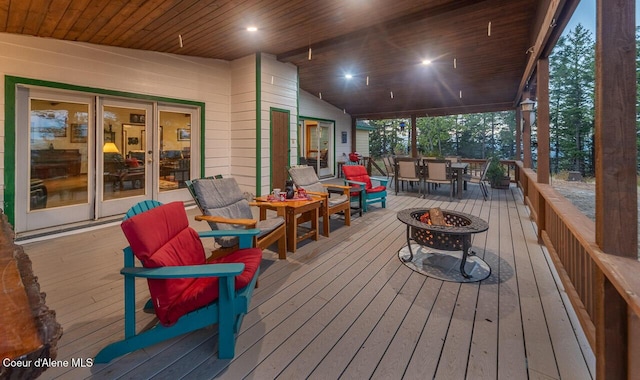 deck featuring french doors, an outdoor fire pit, and outdoor dining space