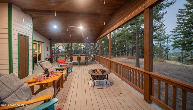 wooden deck with an outdoor fire pit and outdoor dining space