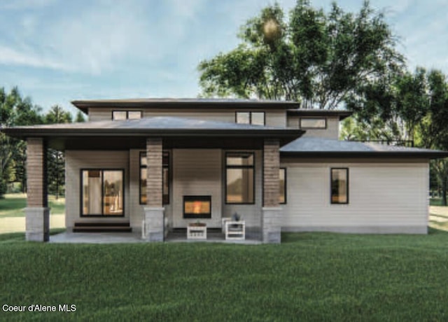 rear view of house featuring a fireplace and a yard