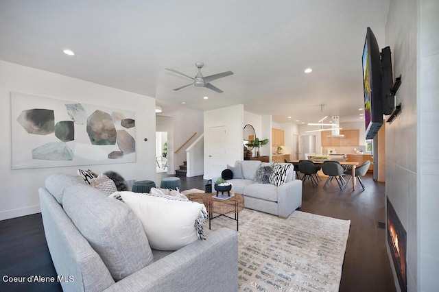 living area with ceiling fan, recessed lighting, stairway, a wealth of natural light, and dark wood-style floors