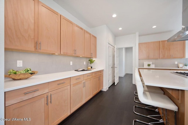 kitchen with dark wood-style flooring, light countertops, light brown cabinets, and extractor fan