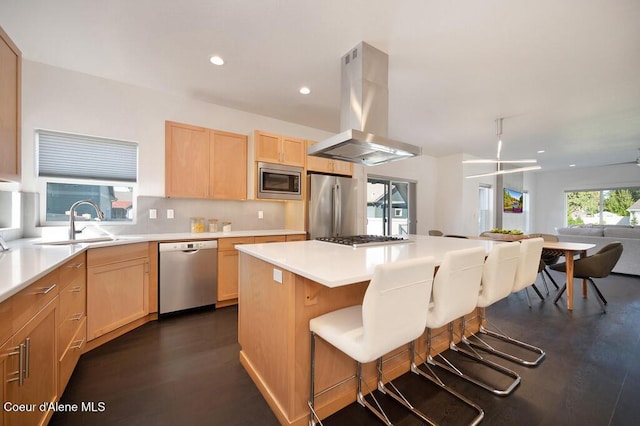 kitchen featuring island range hood, a kitchen island, a breakfast bar, stainless steel appliances, and light countertops