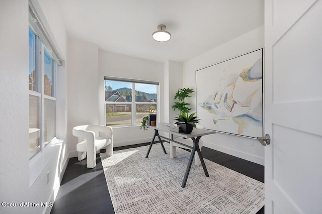 home office with baseboards and wood finished floors