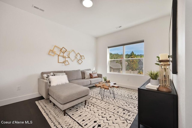 living room featuring baseboards, visible vents, and wood finished floors