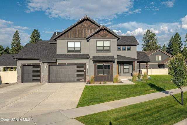 view of front facade with board and batten siding, fence, a front lawn, and concrete driveway