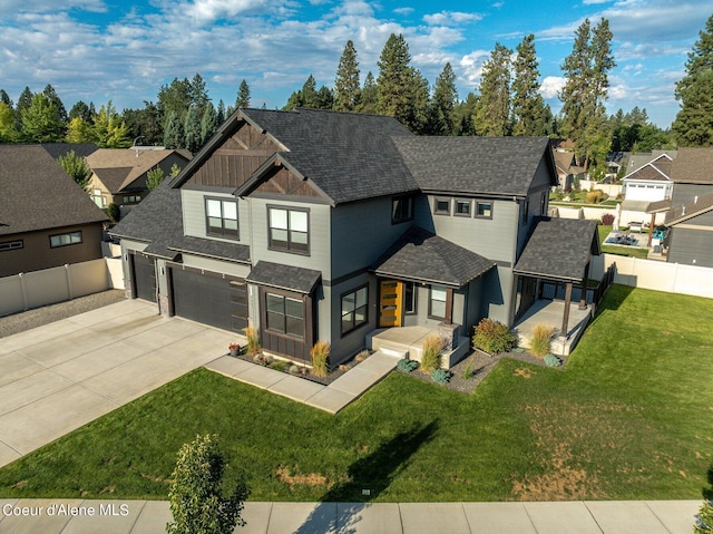 view of front facade with driveway, a residential view, fence, and a front lawn