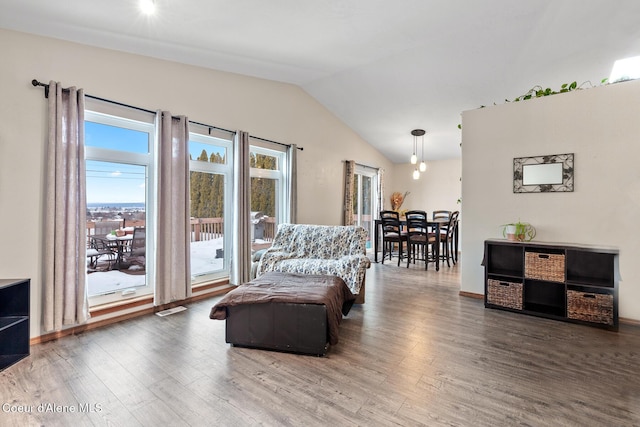 sitting room featuring visible vents, vaulted ceiling, and wood finished floors