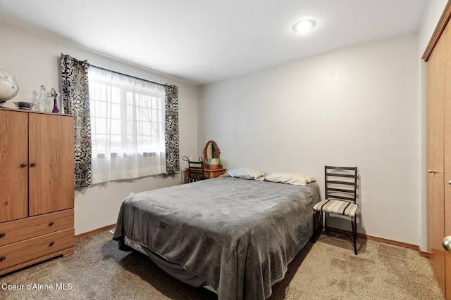 bedroom featuring baseboards and light colored carpet