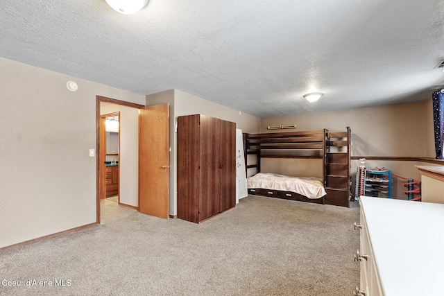 unfurnished bedroom with light carpet, a textured ceiling, and baseboards