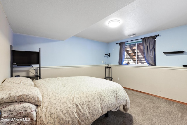 carpeted bedroom with a textured ceiling, visible vents, and baseboards