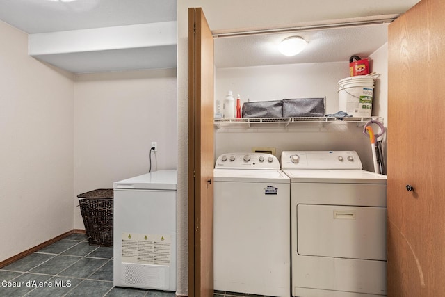 laundry area featuring laundry area, dark tile patterned flooring, independent washer and dryer, and baseboards