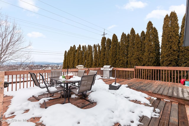 snow covered deck featuring outdoor dining area