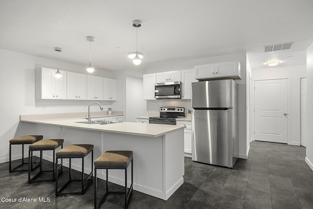 kitchen featuring visible vents, appliances with stainless steel finishes, a peninsula, light countertops, and white cabinetry