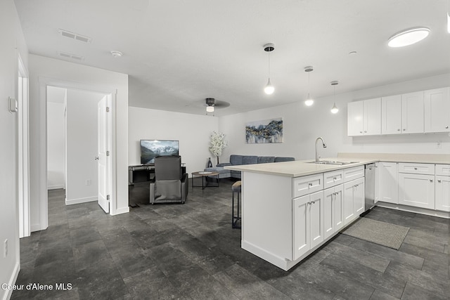 kitchen with decorative light fixtures, white cabinets, light countertops, and a peninsula