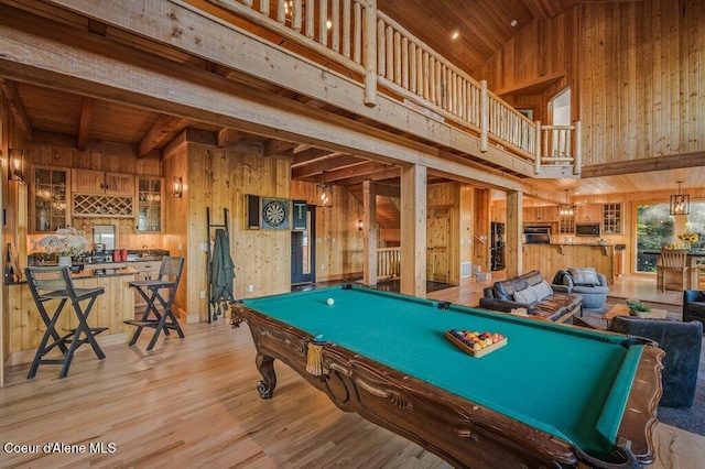 playroom with a high ceiling, wood walls, wood finished floors, and wood ceiling