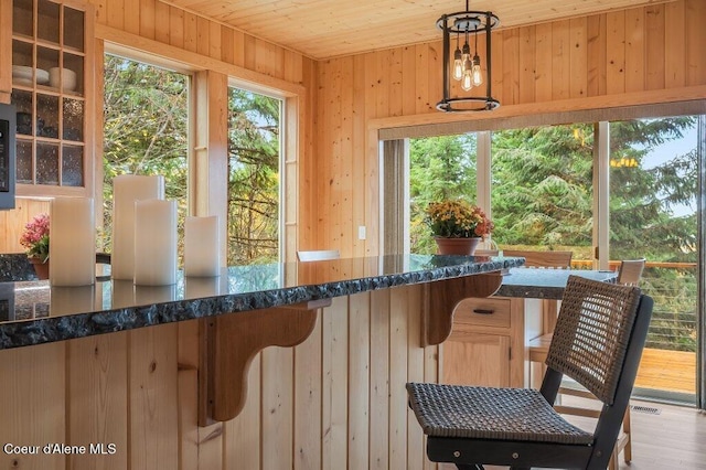 sunroom featuring plenty of natural light and wooden ceiling