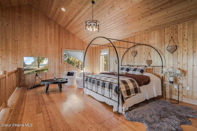 bedroom with high vaulted ceiling, wood ceiling, wooden walls, and hardwood / wood-style flooring