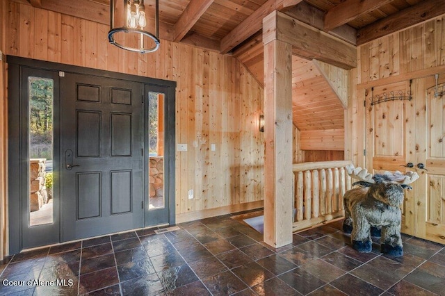 entrance foyer featuring wooden ceiling, stone tile floors, wooden walls, and beamed ceiling