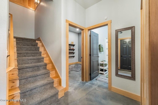 stairs featuring concrete floors and baseboards