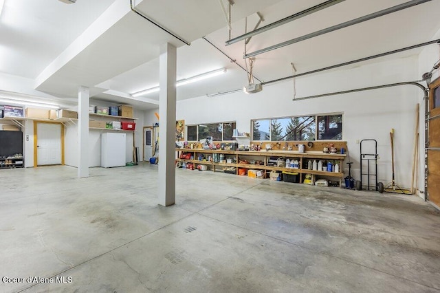 garage with a workshop area and a garage door opener