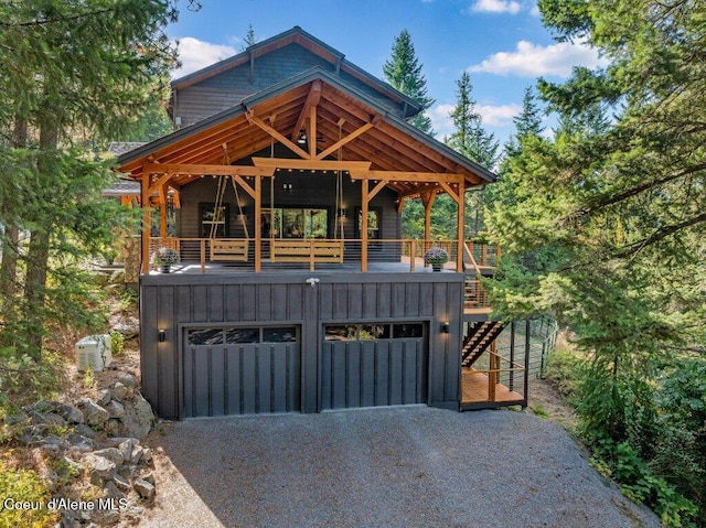 view of front of house featuring driveway, an attached garage, stairway, and board and batten siding