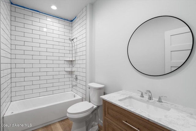 bathroom featuring toilet, recessed lighting, wood finished floors, vanity, and shower / washtub combination