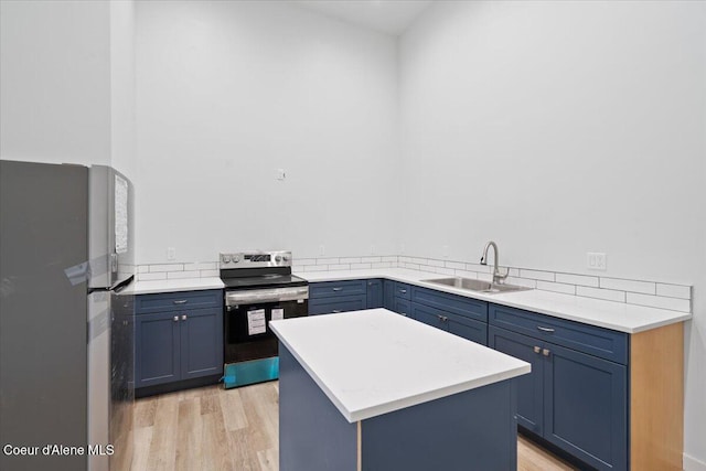 kitchen with light countertops, appliances with stainless steel finishes, blue cabinetry, and a sink