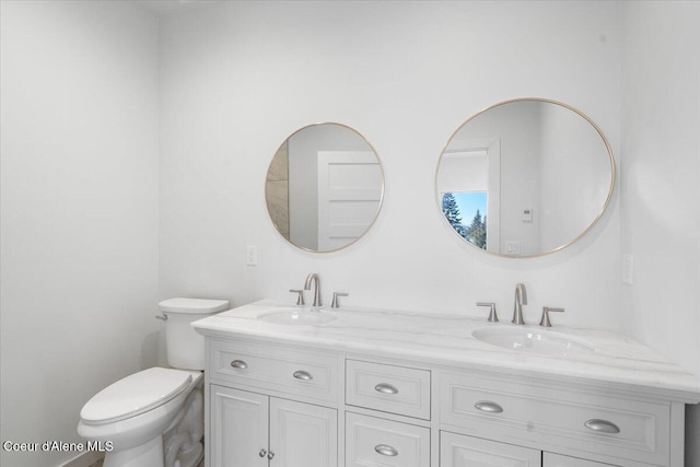 full bathroom with a sink, toilet, and double vanity