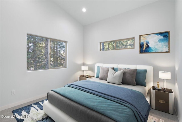 bedroom featuring carpet floors, multiple windows, baseboards, and lofted ceiling