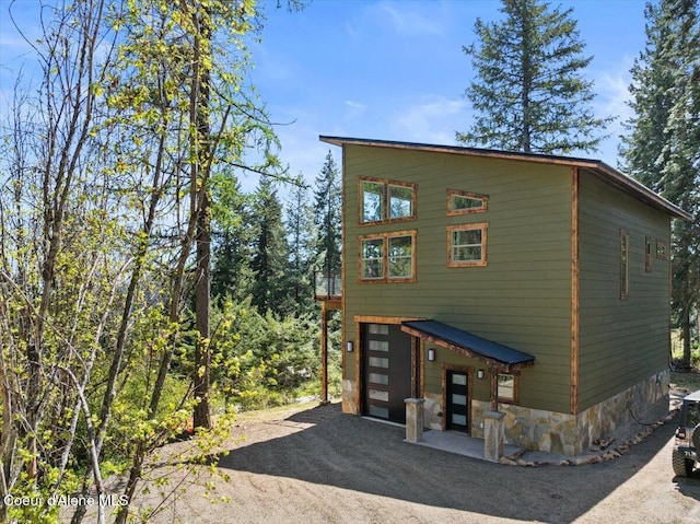 21941 S Lakeview Dr, Worley, ID 83876 - view of home's exterior featuring a garage, driveway, and stone siding