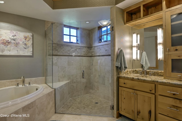 full bathroom featuring a garden tub, a shower stall, and vanity