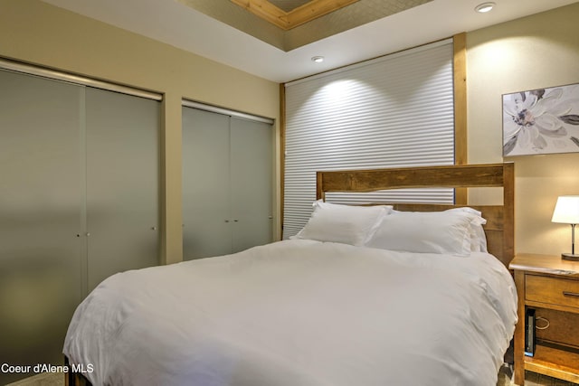 bedroom featuring multiple closets and recessed lighting