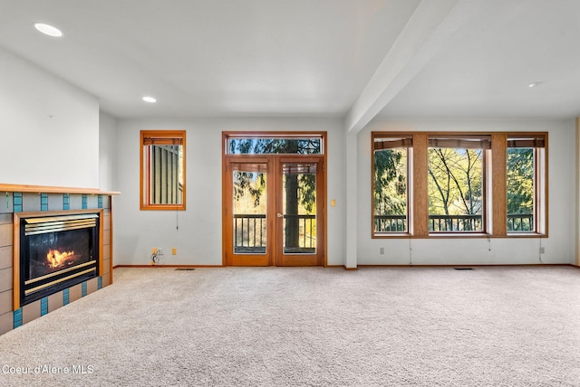 living area featuring carpet floors, visible vents, plenty of natural light, and a fireplace