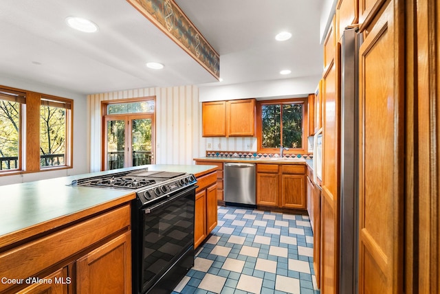 kitchen with black gas range, recessed lighting, a sink, light countertops, and dishwasher