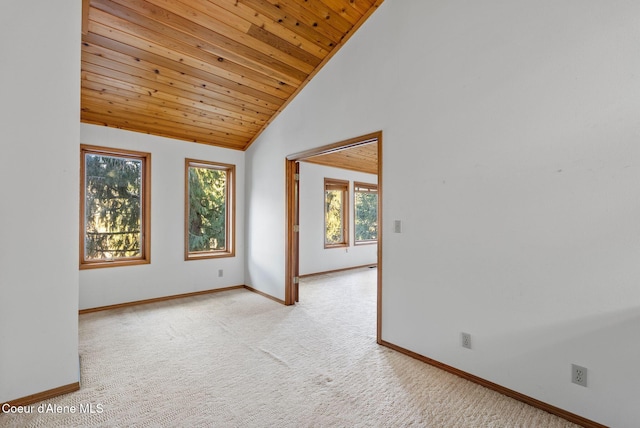 empty room with light carpet, high vaulted ceiling, wood ceiling, and baseboards