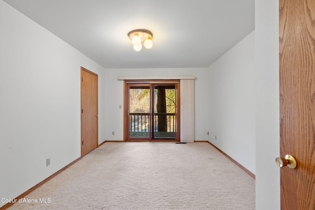 unfurnished room with light colored carpet and baseboards