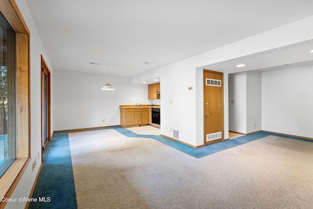 unfurnished living room featuring light carpet, baseboards, and visible vents