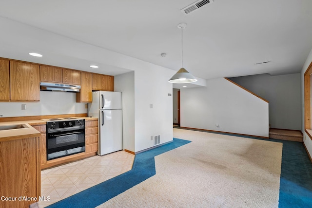 kitchen with wall oven, freestanding refrigerator, hanging light fixtures, light countertops, and under cabinet range hood