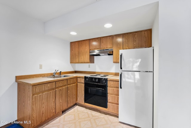 kitchen with light countertops, freestanding refrigerator, a sink, range with electric cooktop, and under cabinet range hood