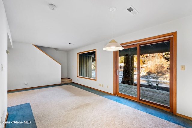 unfurnished room with carpet flooring, visible vents, and baseboards