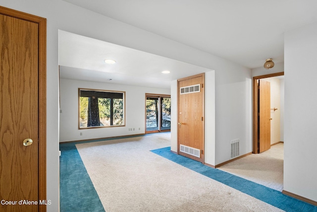 interior space with light carpet, visible vents, and baseboards