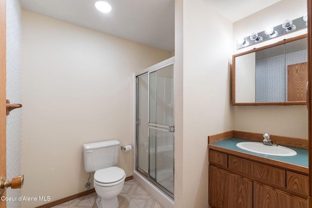 full bath with a stall shower, baseboards, vanity, and toilet