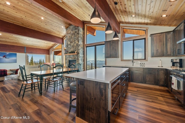 kitchen with lofted ceiling with beams, dark brown cabinetry, a sink, decorative backsplash, and gas range