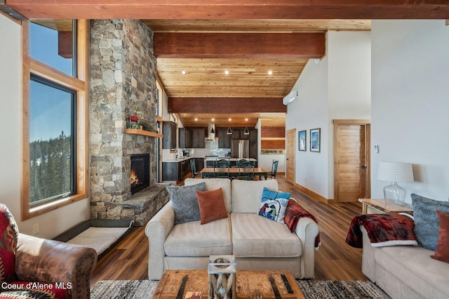 living room with high vaulted ceiling, beamed ceiling, a stone fireplace, and wood finished floors