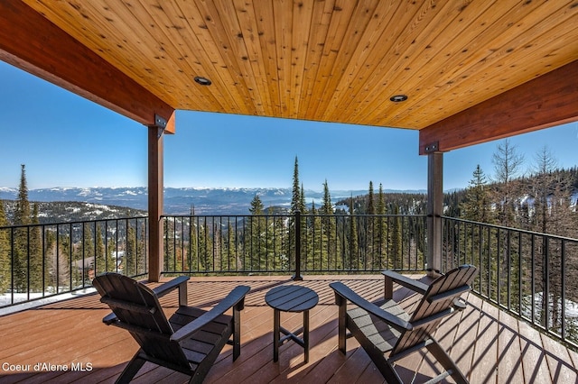 deck featuring a mountain view and a wooded view