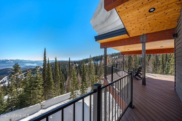 wooden deck featuring a forest view and a mountain view