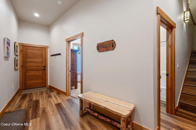 interior space with stairs, recessed lighting, wood finished floors, and baseboards