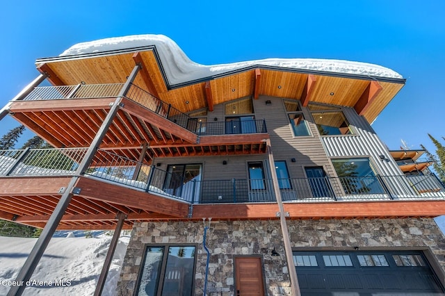 exterior space featuring an attached garage and stone siding