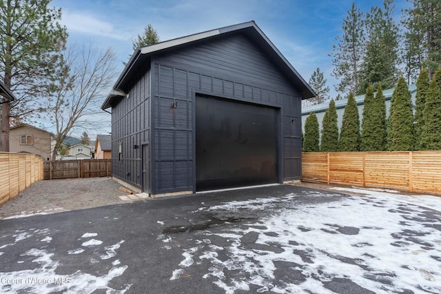 detached garage with aphalt driveway and fence