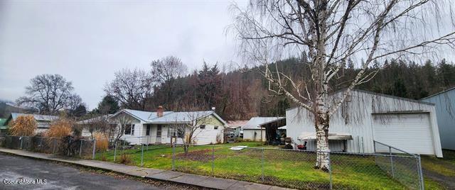 view of front facade with a garage, a front yard, and fence